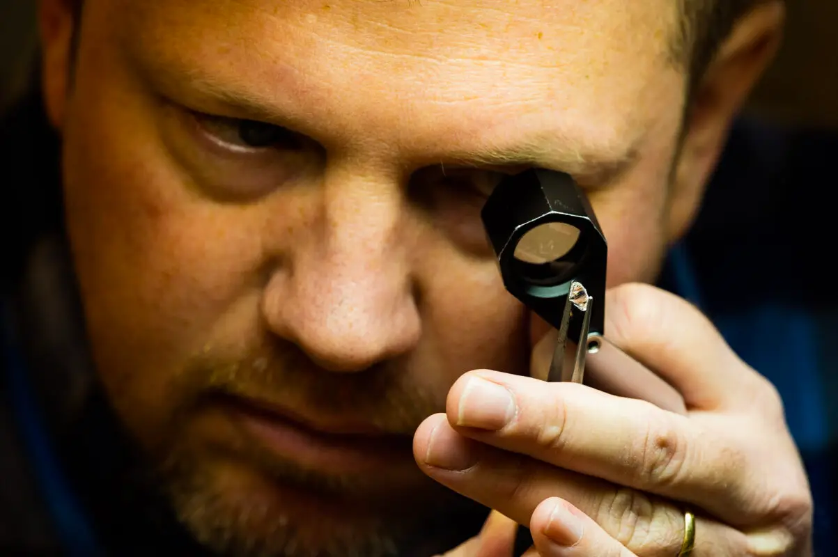 Jeweler viewing a diamond through a loupe